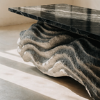 The Wave Coffee Table in black and grey veined marble — organic wave-carved base, architectural detail